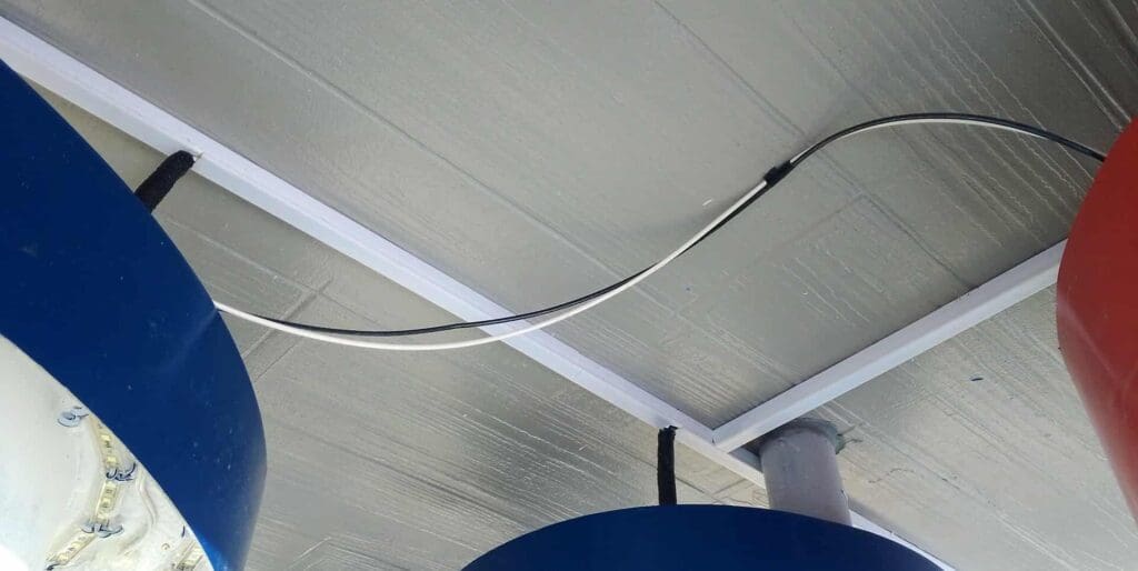 Indoor acrylic room signage installation with blue and red accents, gray ceiling cable, sign maker Philippines by M&G Global Ads.