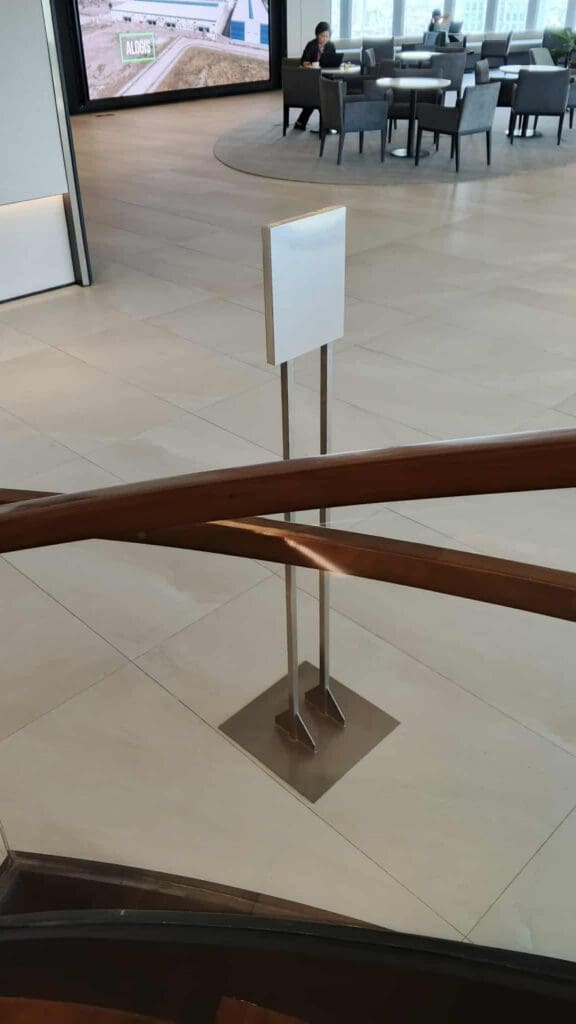 Indoor acrylic sign on metal stands near staircase in Metro Manila by sign maker Philippines, by M&G Global Ads.
