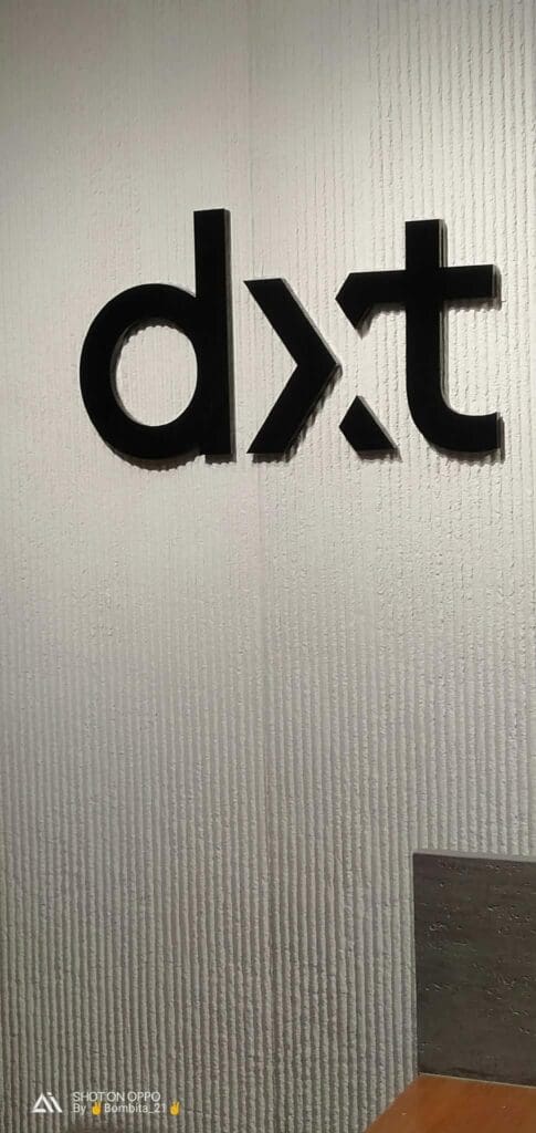 Indoor acrylic signage of black lowercase letters "dxt" on a textured white wall, Metro Manila sign maker Philippines by M&G Global Ads.