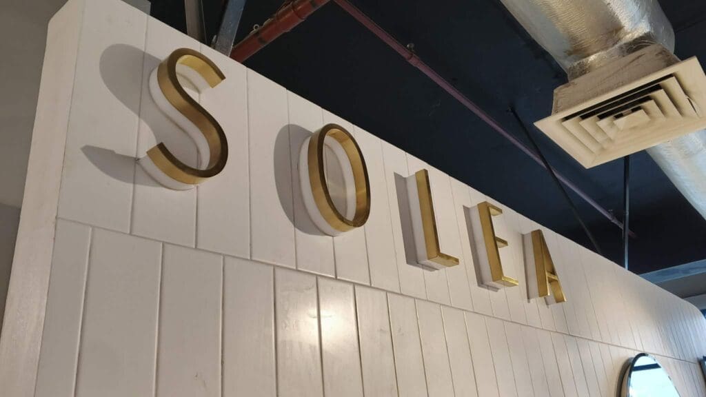 Indoor brass building signage for SOLEA on white paneled wall, Metro Manila, sign maker Philippines by M&G Global Ads.