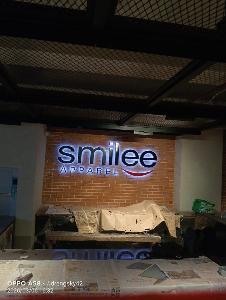 Indoor LED acrylic signage for smilee APPAREL on brick wall, Metro Manila, sign maker Philippines by M&G Global Ads.