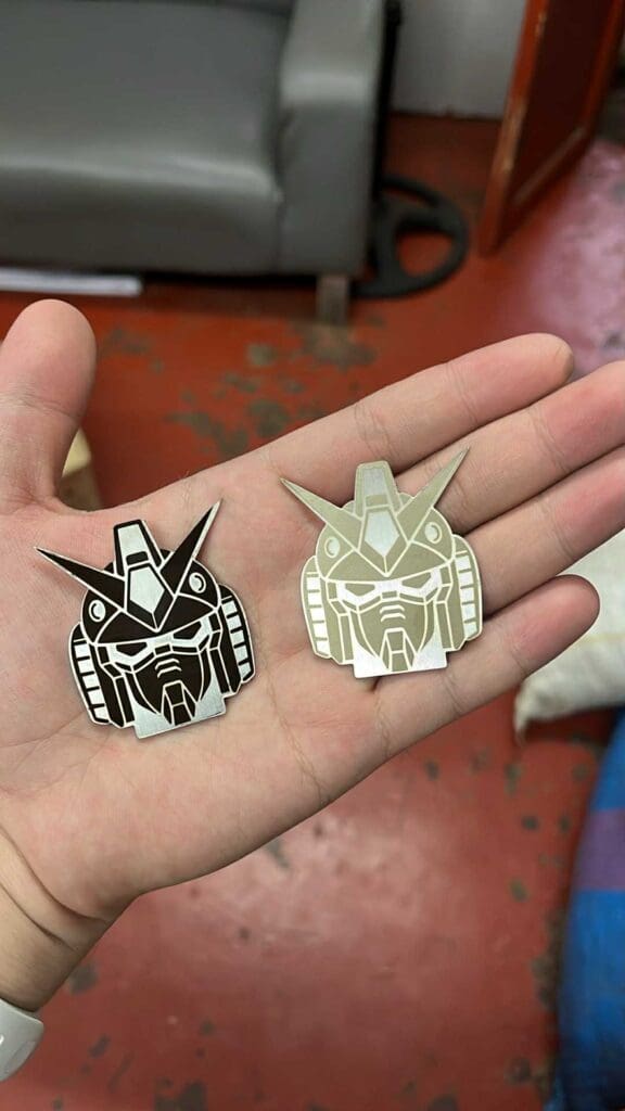 Stainless steel and brass engraved pins, Gundam design, custom signage by sign maker Philippines. Photo taken in Metro Manila by M&G Global Ads.