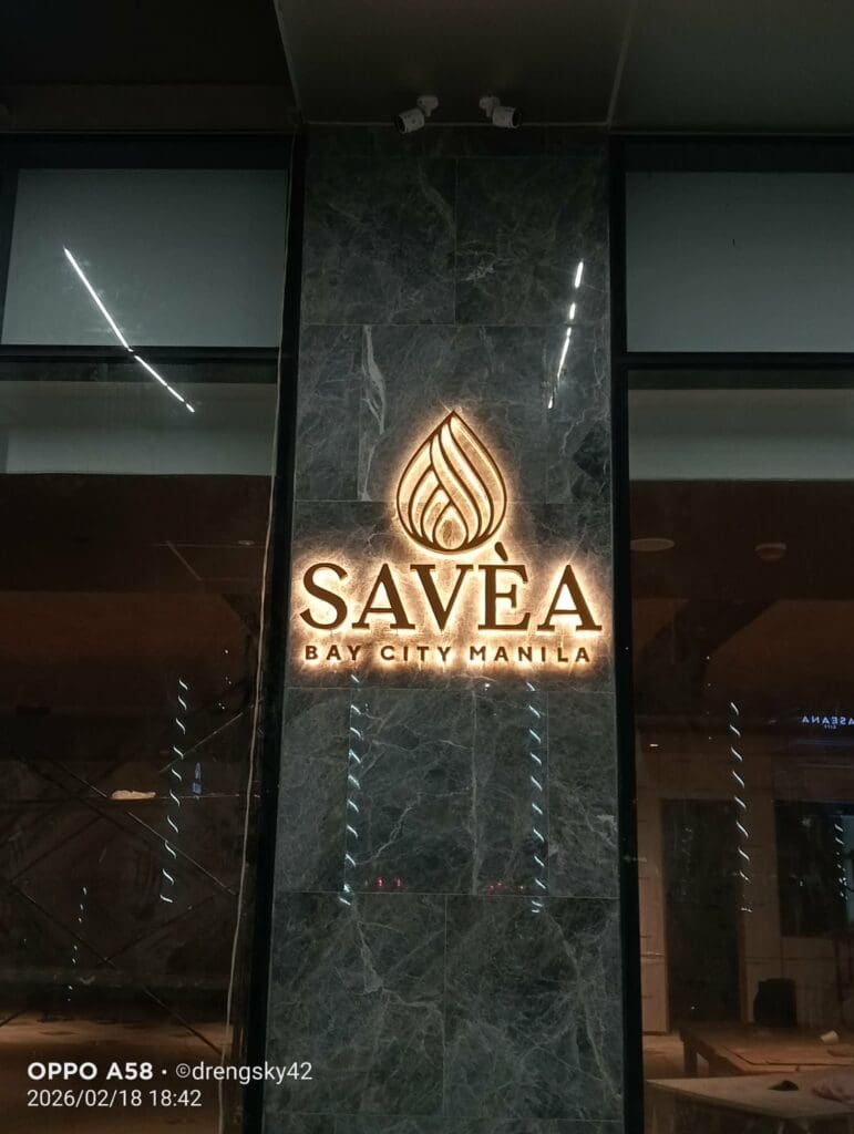 LED acrylic illuminated signage for SAVÈA Bay City, Manila on marble wall at night, sign maker Philippines by M&G Global Ads.