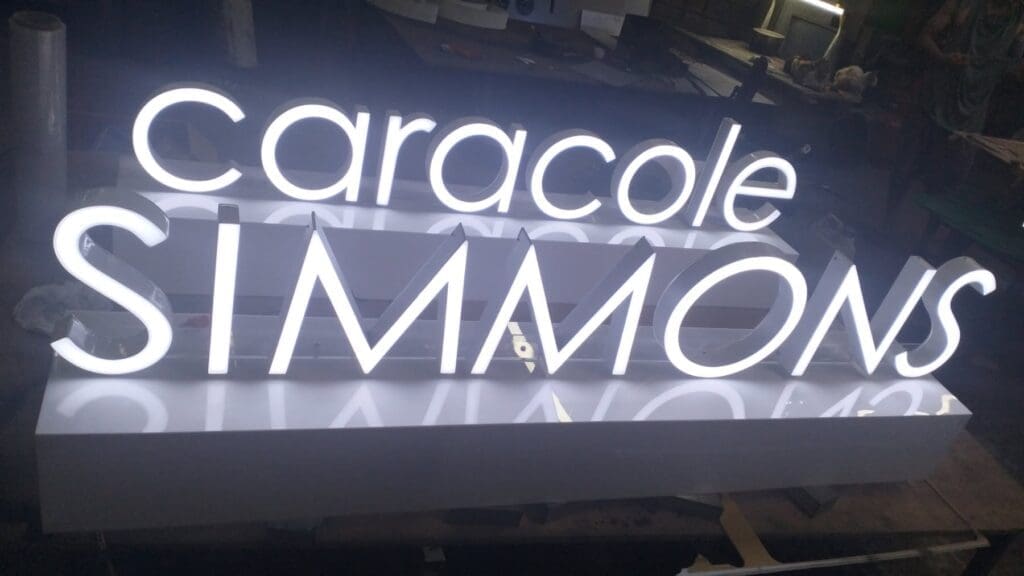 LED acrylic indoor signage with caracole SIMMONS text, workbench setting, Metro Manila sign maker Philippines by M&G Global Ads.