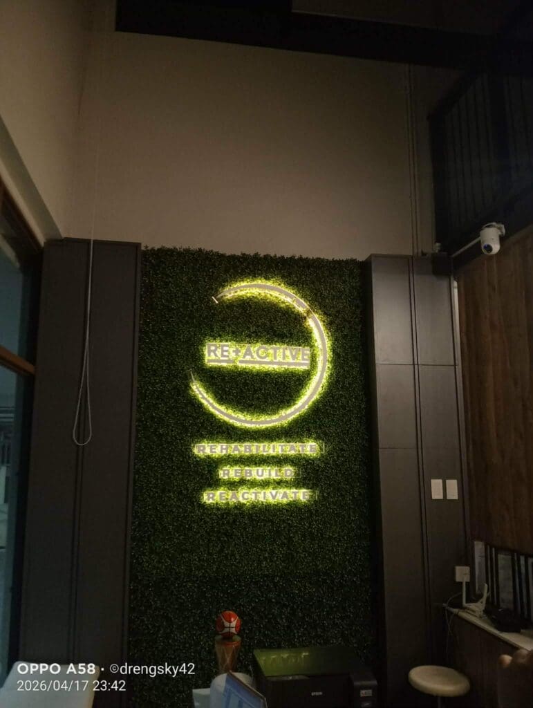 LED illuminated signage for RE:ACTIVE with tagline, indoor acrylic sign on green wall, Metro Manila. Sign maker Philippines by M&G Global Ads.