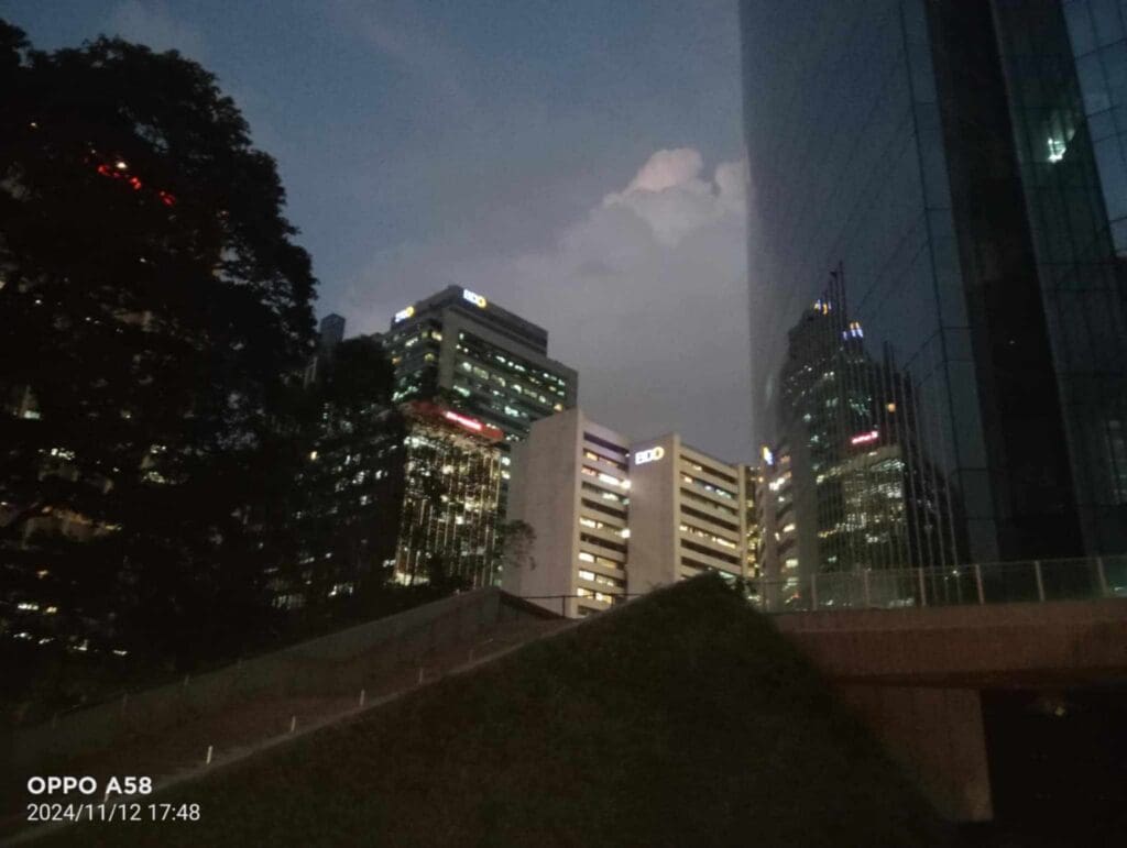 Metro Manila cityscape at dusk with illuminated BDO buildings and skyscraper, building signage by sign maker Philippines by M&G Global Ads.