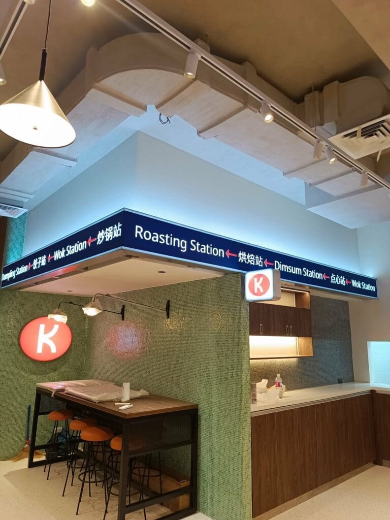 Modern cafeteria with LED acrylic indoor wayfinding signs (“Roasting,” “Dimsum,” “Wok”), sign maker Philippines by M&G Global Ads.