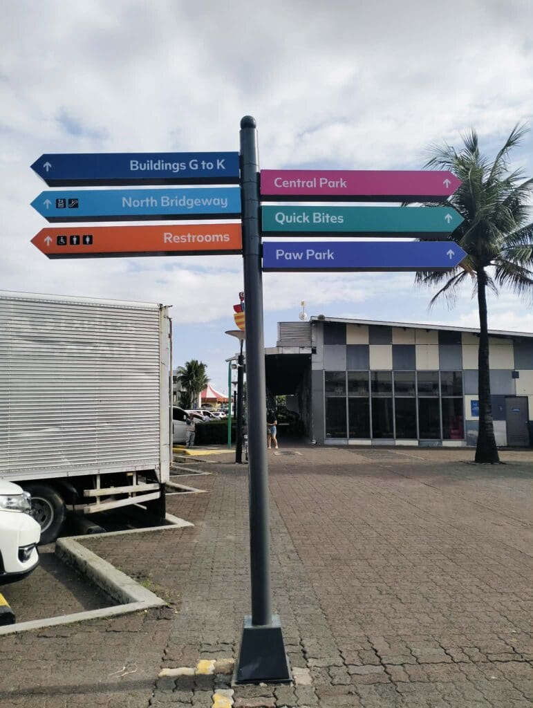 Outdoor acrylic wayfinding signpost with colorful arrows at Metro Manila by sign maker Philippines, by M&G Global Ads.