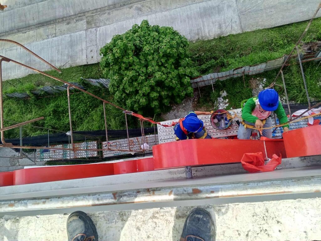 Outdoor building safety signage installation by sign maker Philippines on scaffolding, Metro Manila, by M&G Global Ads.