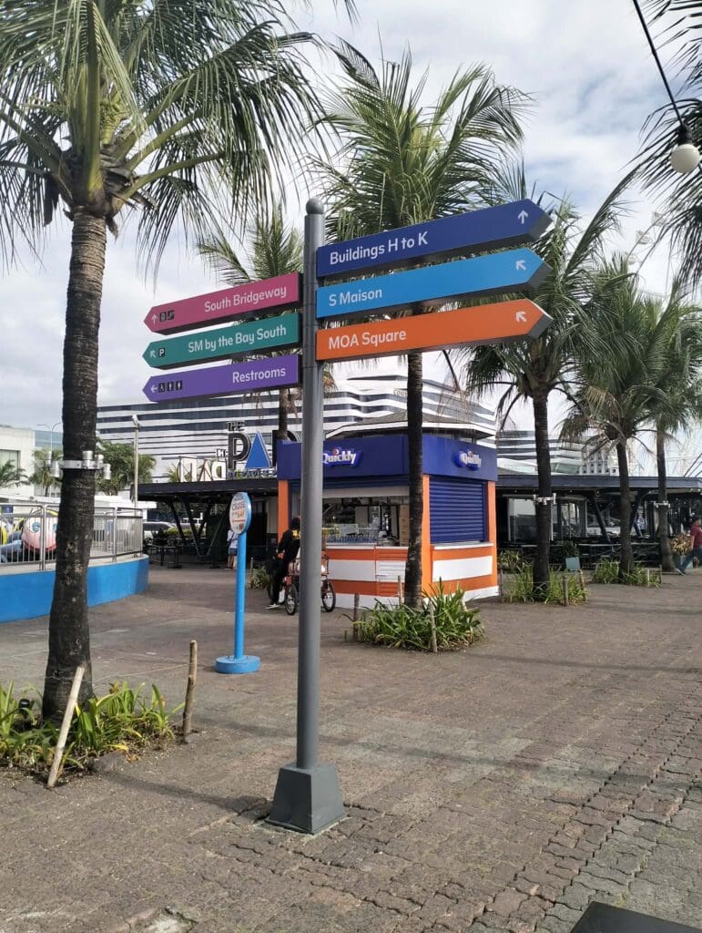 Outdoor wayfinding acrylic signpost with directional arrows at MOA, Metro Manila by sign maker Philippines by M&G Global Ads.