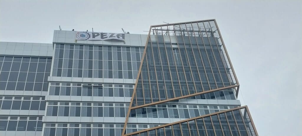 PEZA acrylic building signage on a modern glass office in Metro Manila by sign maker Philippines, M&G Global Ads.