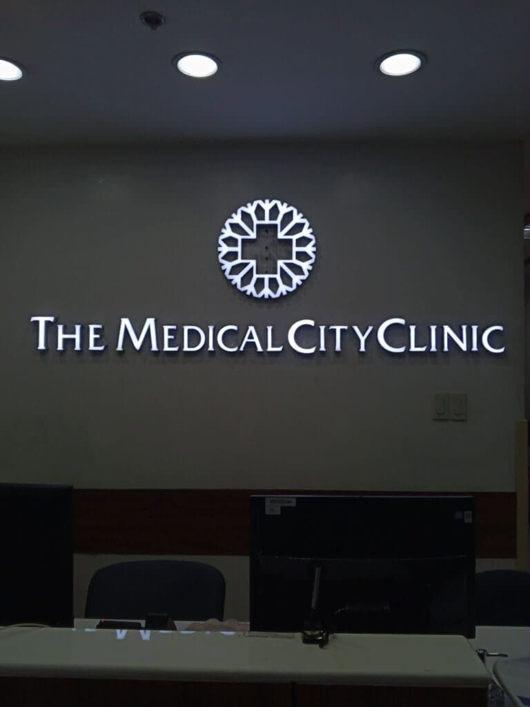 Reception area with an indoor illuminated acrylic signage reading "The Medical City Clinic" and a circular medical-themed logo above the desk, for The Medical City Clinic, Metro Manila, sign maker Philippines by M&G Global Ads.
