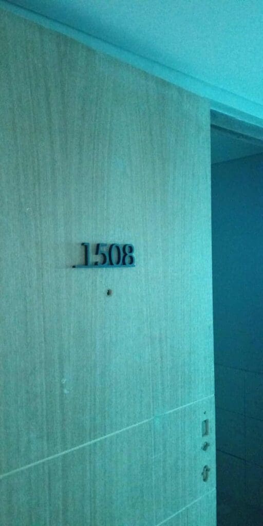 Room signage with black acrylic number 1508 on a light wooden door, Metro Manila. Sign maker Philippines by M&G Global Ads.