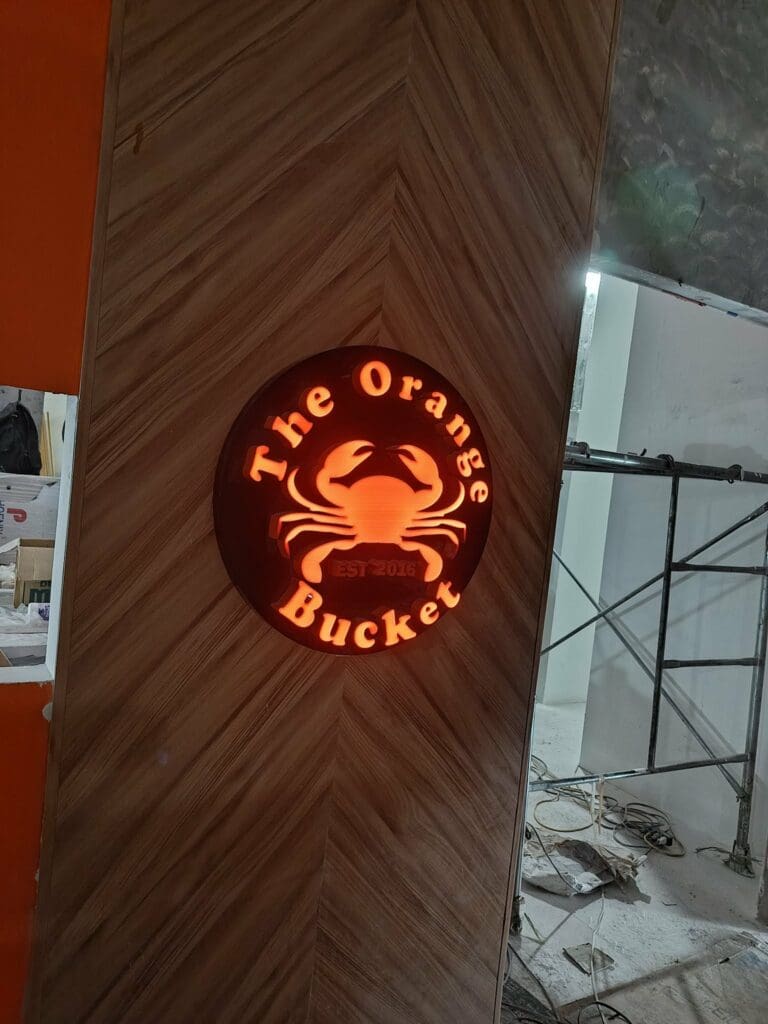Round acrylic illuminated building signage for The Orange Bucket with orange crab, Metro Manila, sign maker Philippines by M&G Global Ads.
