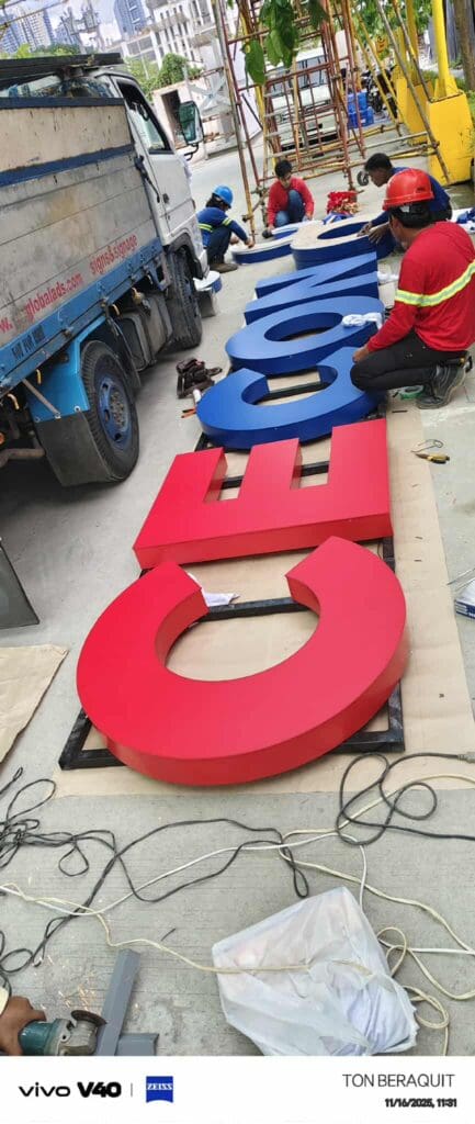 Sign maker Philippines assembles large acrylic 3D letters at outdoor site in Metro Manila by M&G Global Ads.