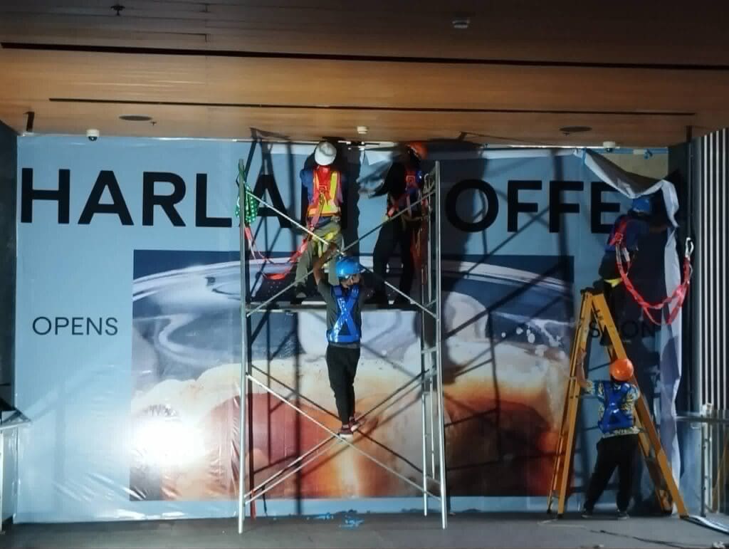 Sign maker Philippines installing outdoor building banner signage for HARLA COFFE storefront, Metro Manila by M&G Global Ads.