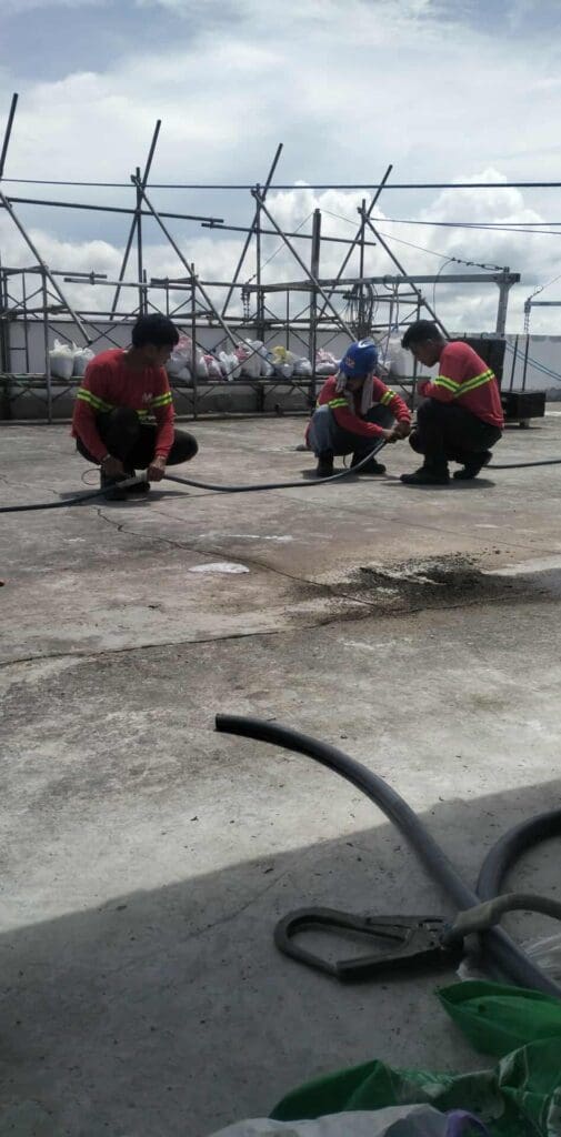 Sign maker Philippines installing outdoor building signage on rooftop, construction site in Metro Manila by M&G Global Ads.