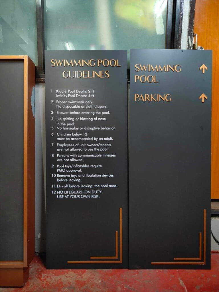 Swimming pool safety guidelines and parking wayfinding acrylic signage, black with orange and white text, Metro Manila. Sign maker Philippines by M&G Global Ads.