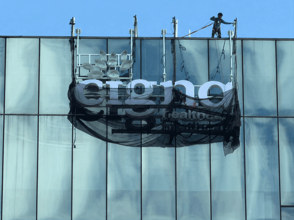Worker on glass building roof installing Cigna outdoor building signage, sign maker Philippines, Metro Manila, by M&G Global Ads.